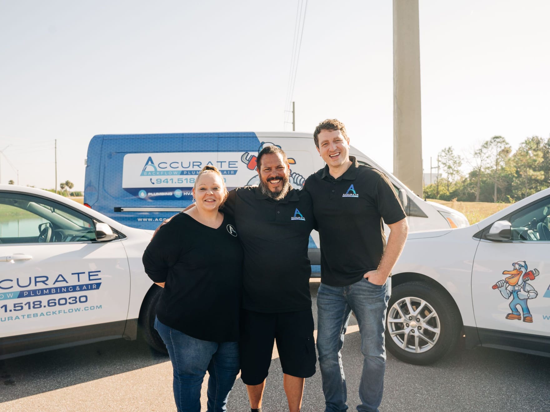 The Accurate Backflow & Plumbing leadership team with the service fleet
