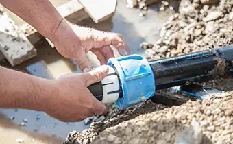 Technician repairing a water main pipe with a compression fitting