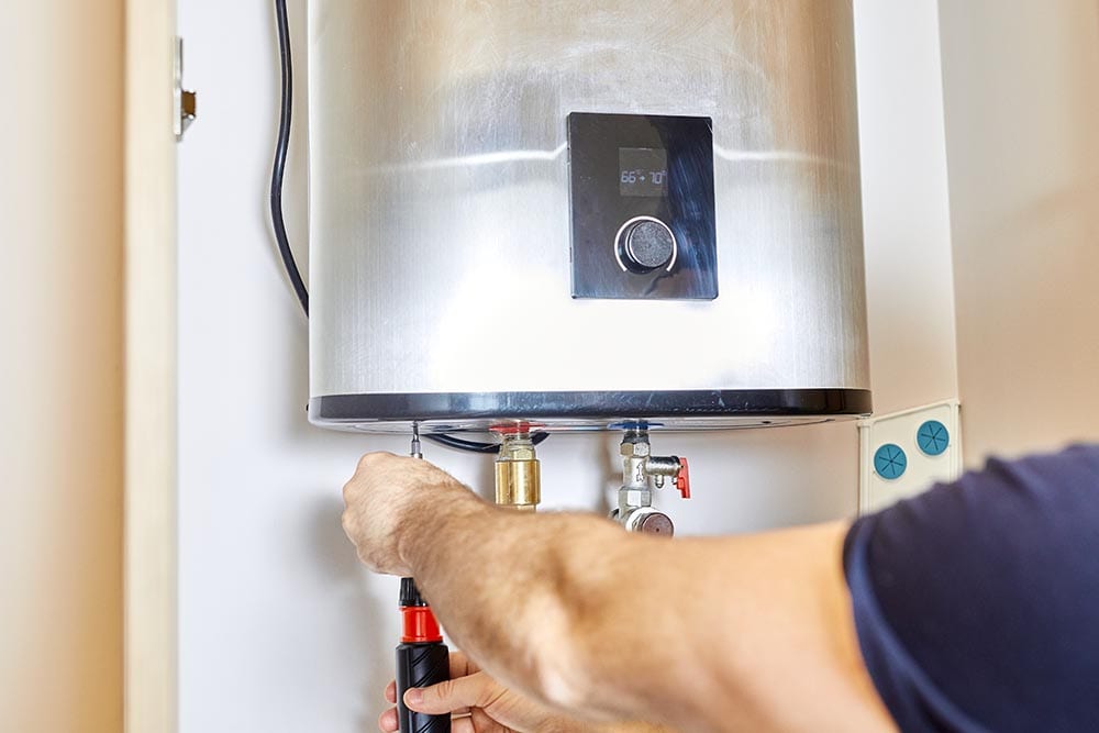 Technician connecting a wall-mounted electric water heater