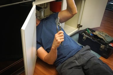 A plumber repairing a pipe