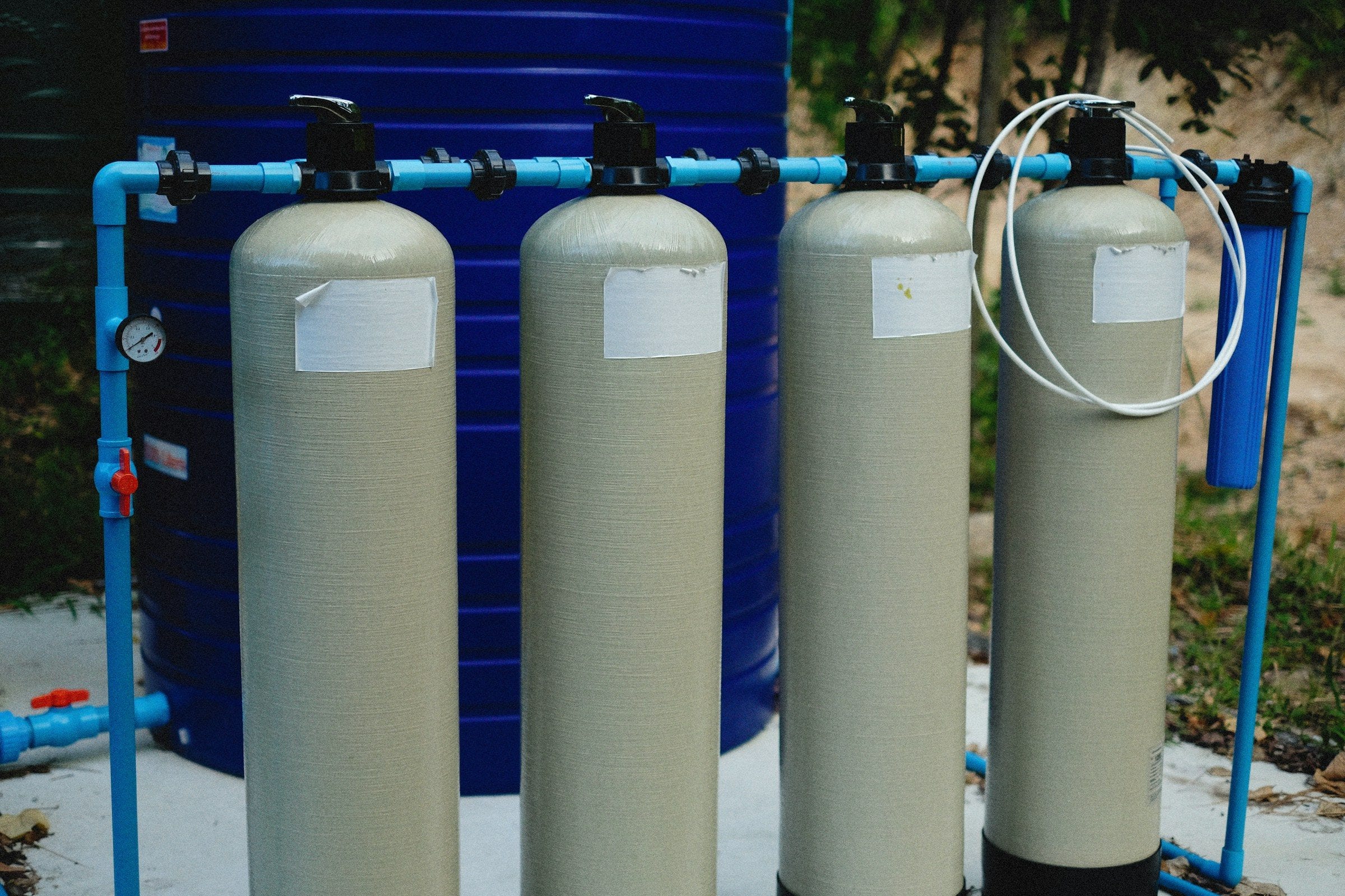Whole-home water filtration tanks connected with blue piping